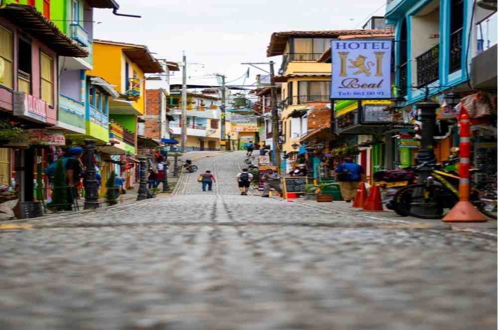 Top 5 Hidden gems places to visit You Must Know Vibrantly painted buildings and decorative zocalos on a cobblestone places to visit street in Guatapรฉ, Antioquia