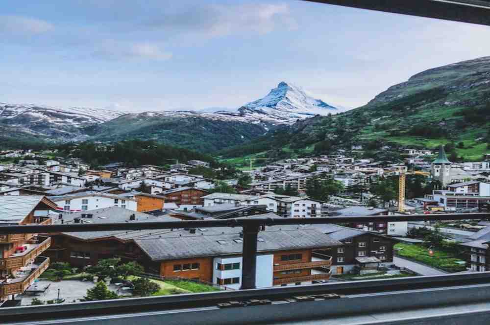 Complete Switzerland Travel Guide 2026 Zermatt, Switzerland with the iconic Matterhorn mountain in the background, traditional alpine chalets, snow-covered peaks, and scenic Complete Switzerland Travel Guide 2026.